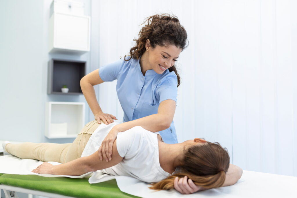 young-woman-doctor-chiropractor-osteopath-fixing-lying-womans-back-with-hands-movements-visit-manual-therapy-clinic-professional-chiropractor-work-1