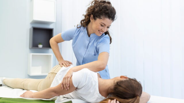 young-woman-doctor-chiropractor-osteopath-fixing-lying-womans-back-with-hands-movements-visit-manual-therapy-clinic-professional-chiropractor-work-1